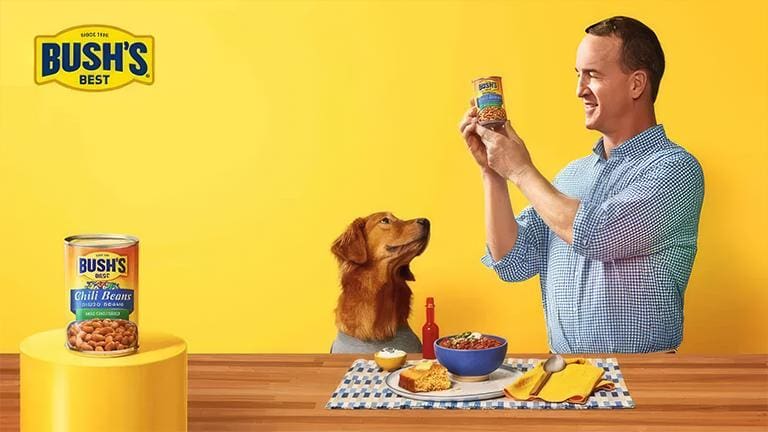 A man and his dog are sitting at the table.